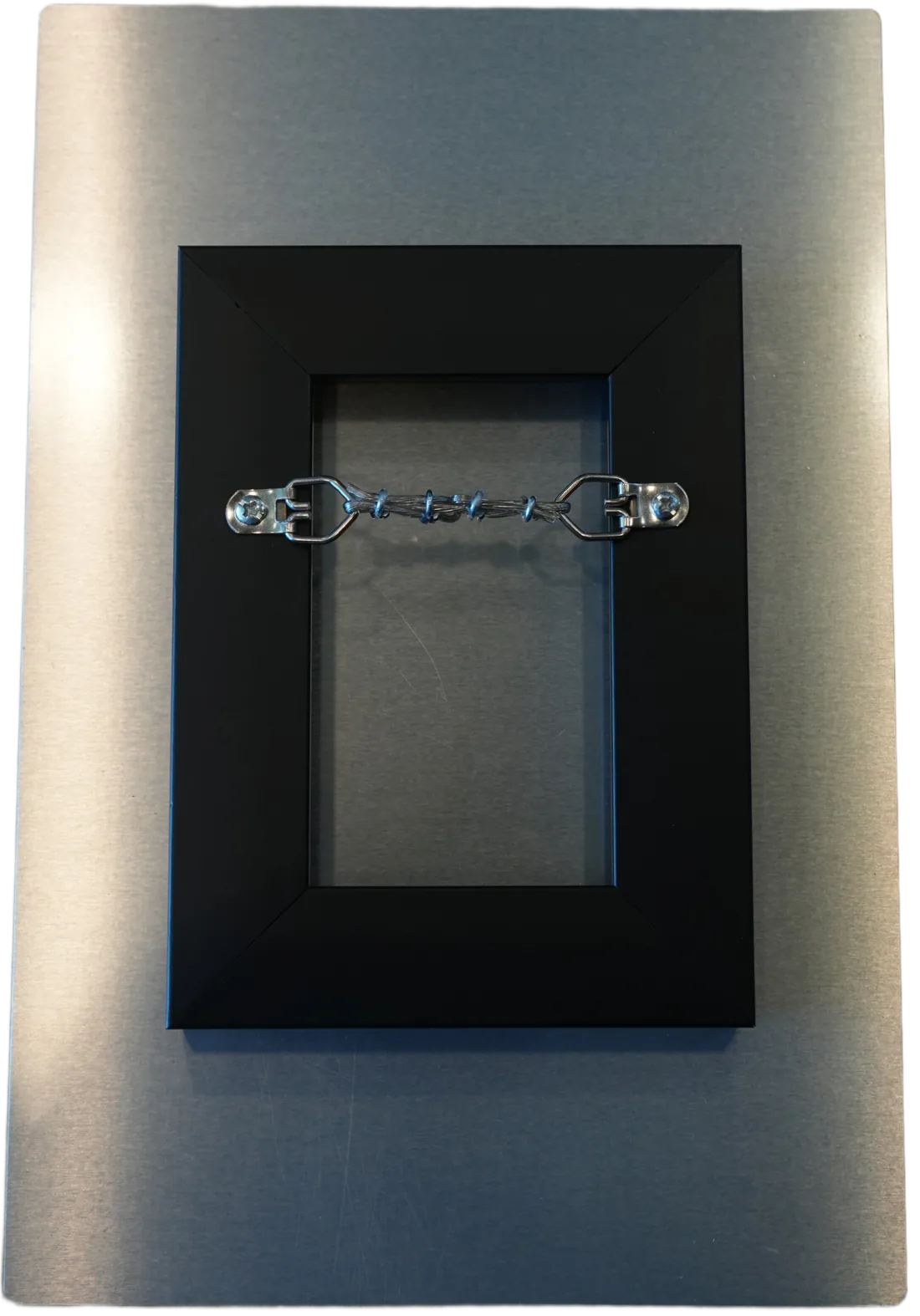 The back of an aluminum print: a black float mount with the hanging wire already installed.